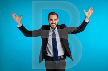 Surprised excited happy businessman on blue background. Man shows yeah gesture of victory, he achieved result, goals. Surprised excited happy businessman on blue background. Man shows yeah gesture of victory, he achieved result, goals.
