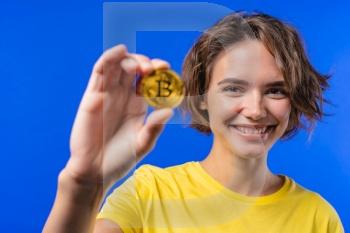 Woman with bitcoin, crypto currency. Golden coin on blue background. Digital exchange, popularity of BTC, symbol of future money, electronics industry, mining concept. High quality photo. Woman with bitcoin, crypto currency. Golden coin on blue background. Digital exchange, popularity of BTC, symbol of future money, electronics industry, mining concept.