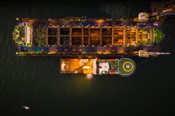 industry shipyard and repairing large ships in the sea aerial view at night over lighting in Thailand