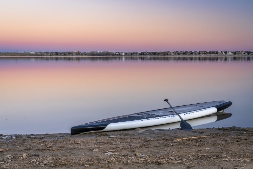 dusk over lake in Colorado with a stand up paddleboard on a beach
