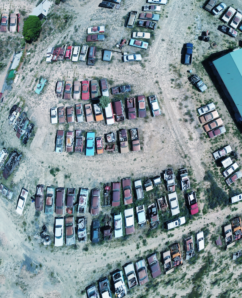 Overhead aerial view of cars wreckage gathered in a countryside parking.