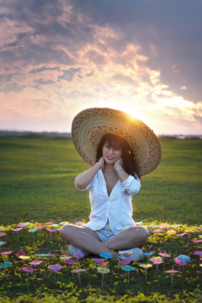 beautiful woman in white dresses and big hat with beautiful nature on sunset times. beautiful woman in white dresses