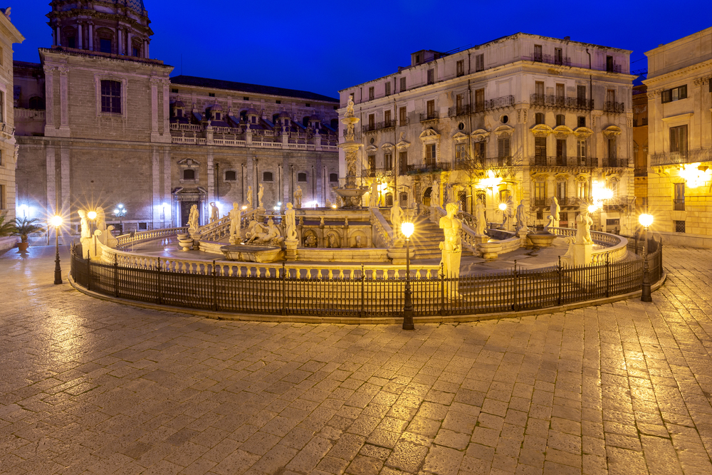 View of the famous Pretoria Square and the fountain at dawn. Palermo. Italy. Sicily.. Palermo. Pretoria Square and the fountain in the night lighting.