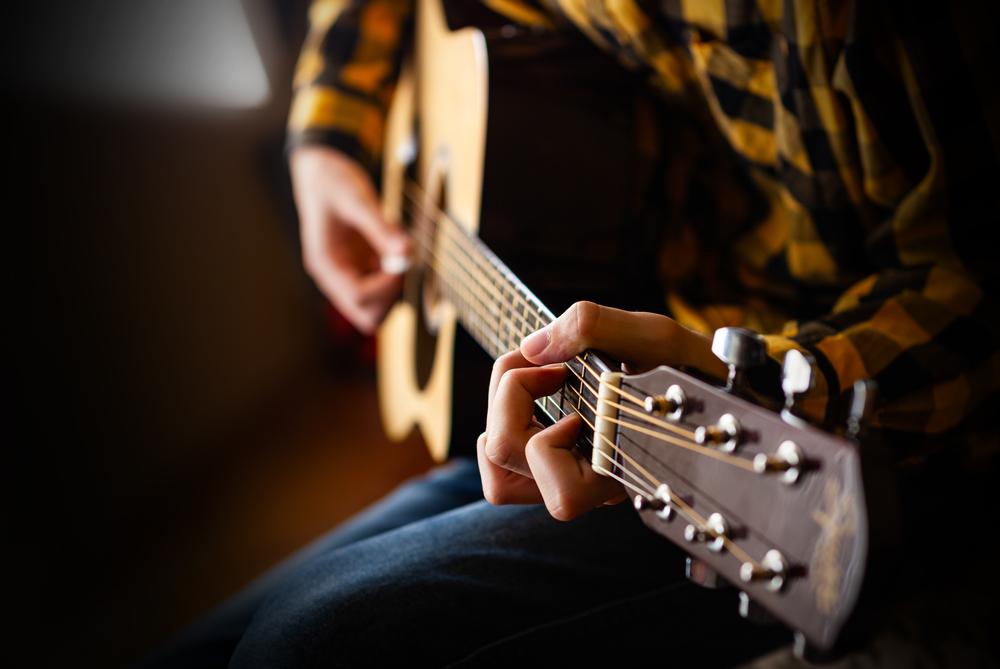 Acoustic Guitar Playing. Young men Playing Acoustic Guitar Closeup Photography.