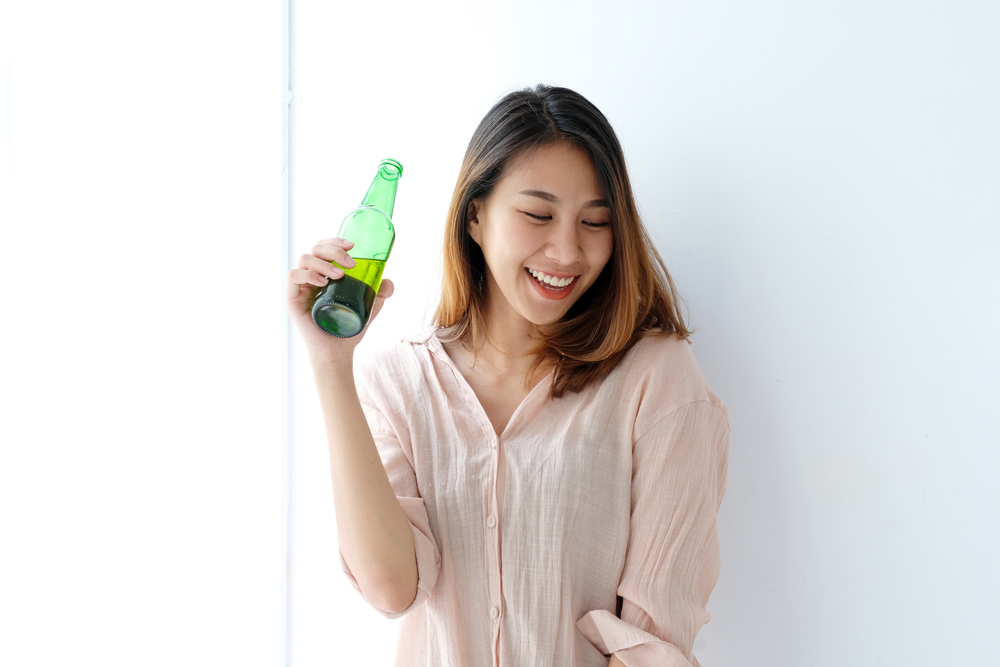 Young asian woman drinking beer at party, celebration, people and lifestyle