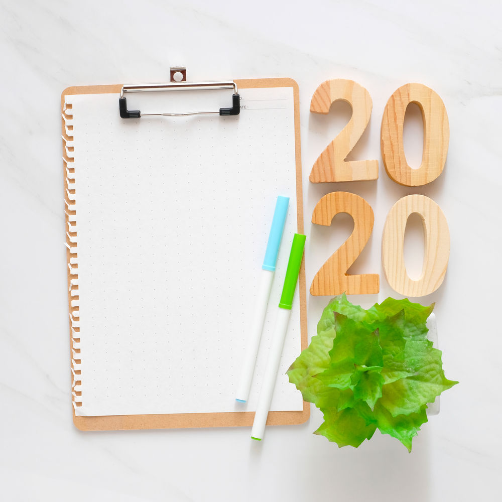 2020 wooden letters and blank notebook paper on white marble table background, 2020 new year mock up, template with copy space for text, top view
