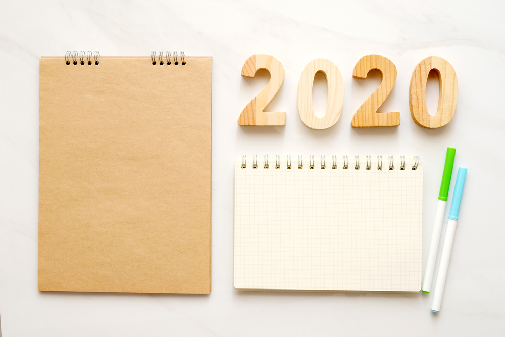 2020 wooden letters and blank notebook paper on white marble table background, 2020 new year mock up, template with copy space for text, top view