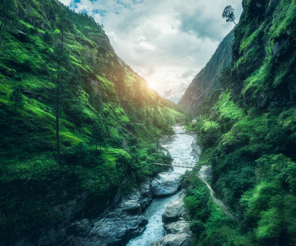 Beautiful mountains covered green grass at sunset. Landscape with mountain canyon, river, meadows and forest, sky with clouds in summer in Nepal in overcast evening. Travel in Himalayas. Nature. Beautiful mountains covered green grass at sunset. Landscape