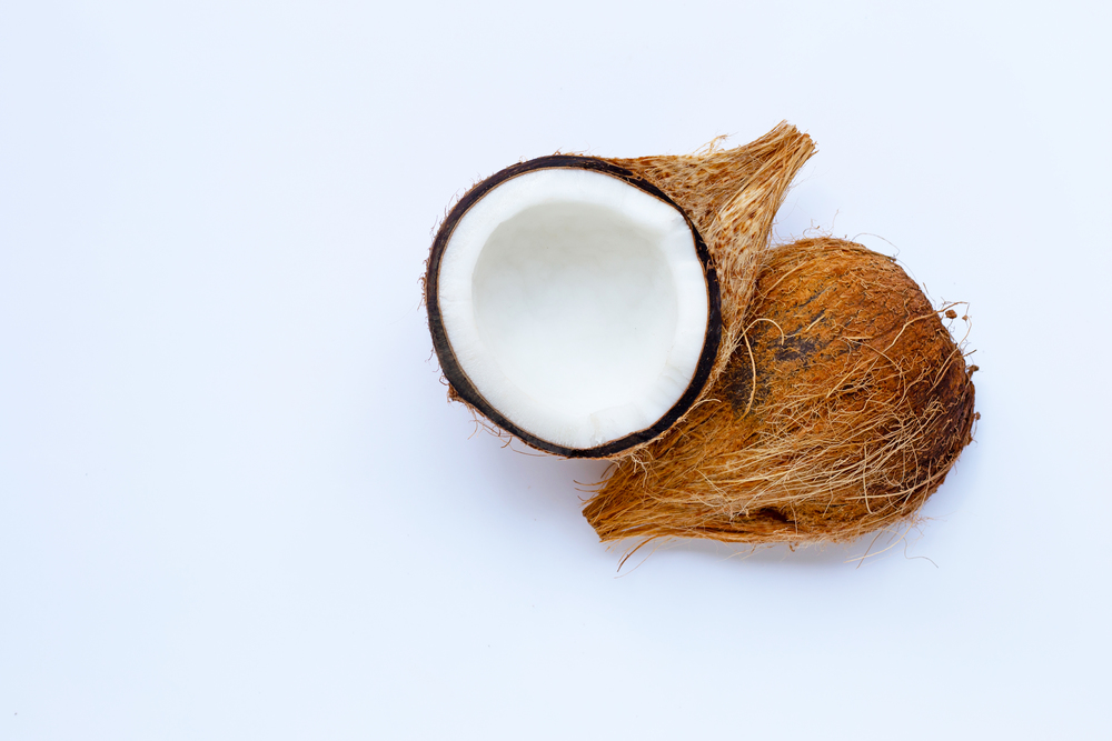 Ripe coconut on white background. Top view of tropical fruit.