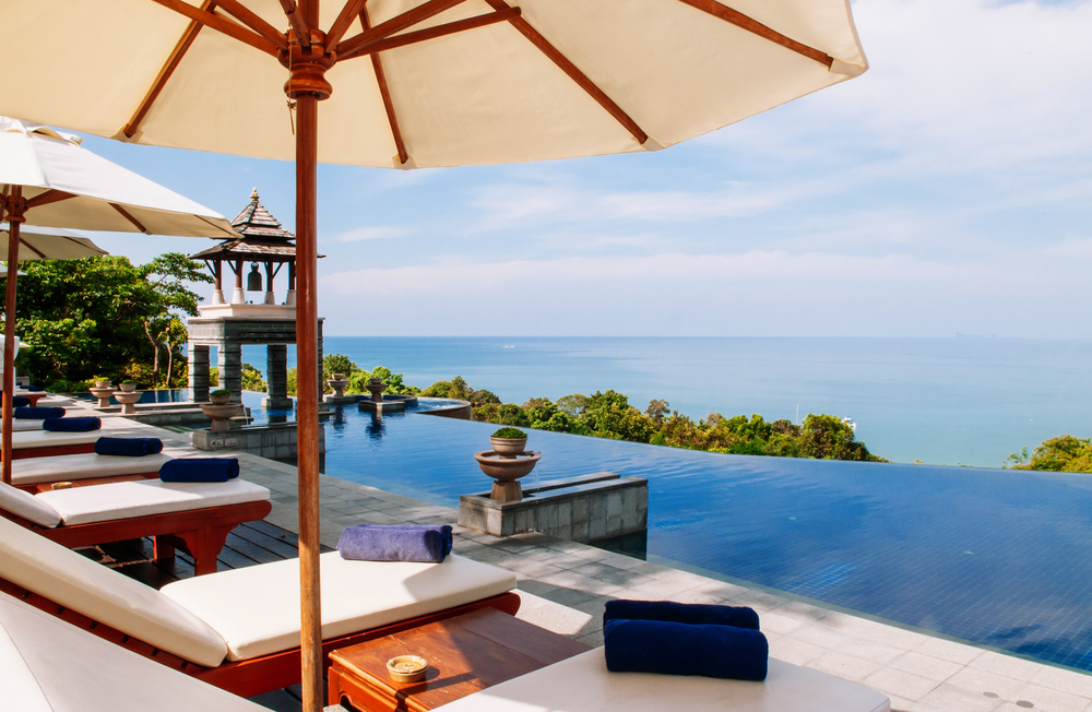 MAY 22, 2014 Krabi, THAILAND - Hill top pool and seascape with pool beds white umbrellas, Koh Lanta tropical resort outdoor space in summer