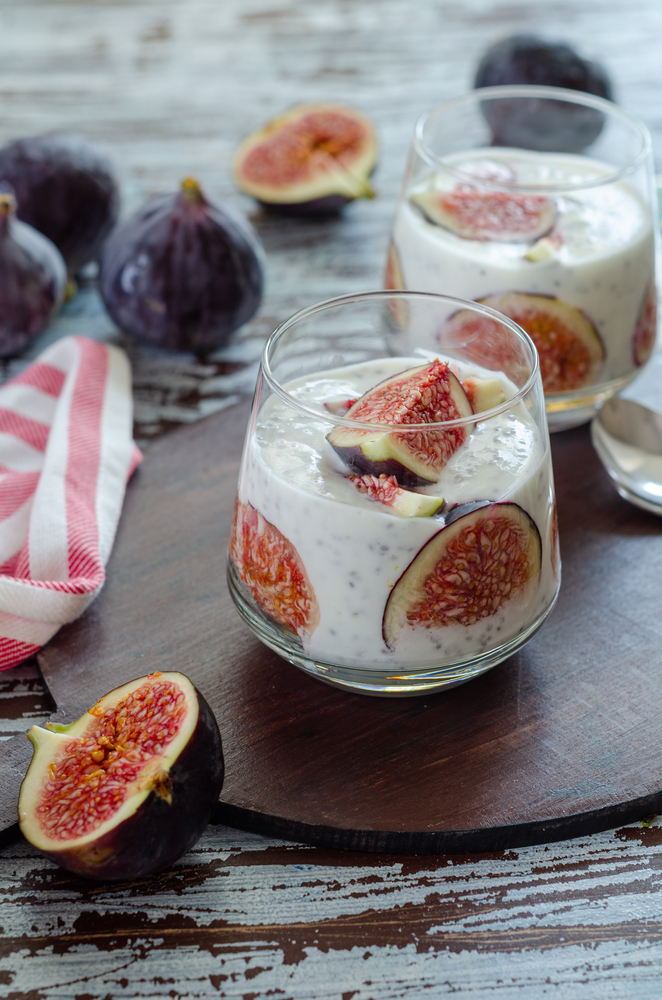 Healthy breakfast from natural ingredients .Homemade yogurt, slice of the fig, chia seeds and yogurt in glasses on  the  wooden background, close up.