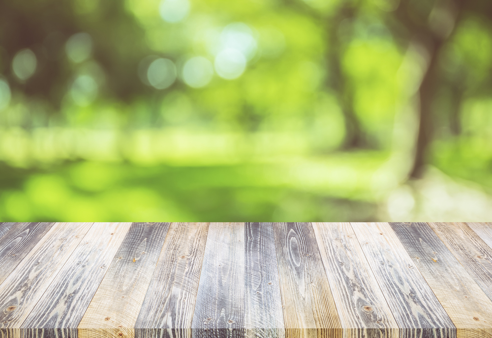 Empty wooden table with nature green outdoor background - can be used for display your products. summer spring concept.