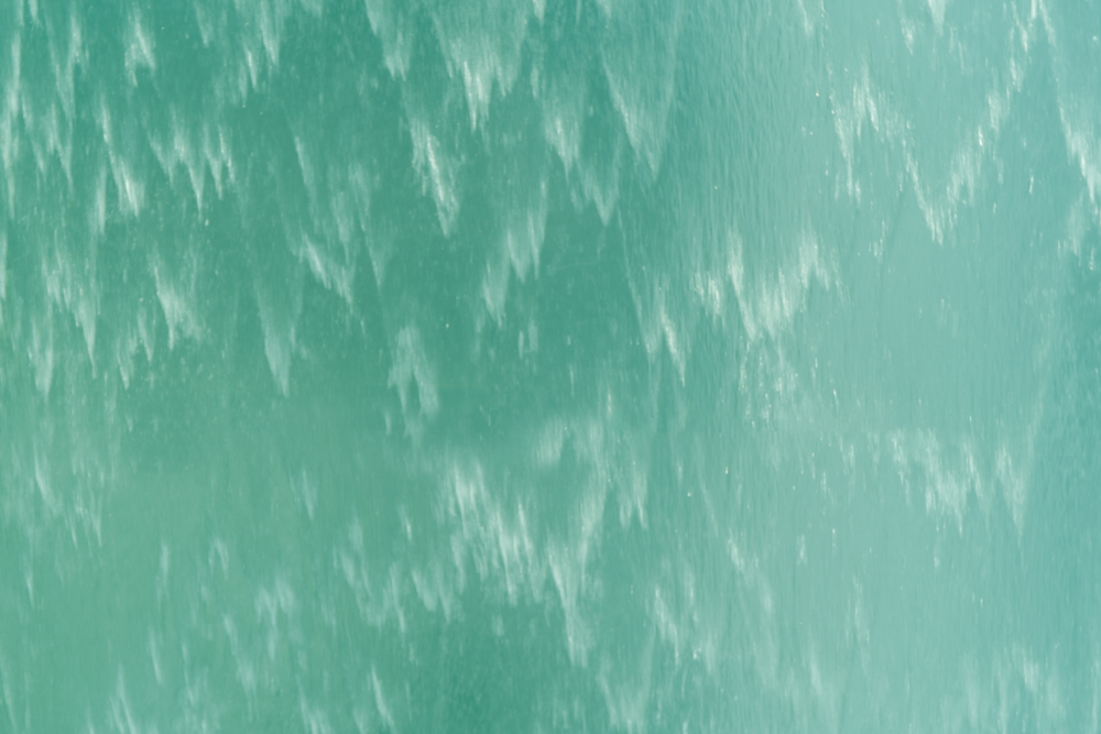 Close up of surface. Blue or turquoise waterfall or swimming pool texture. Pattern background of water.