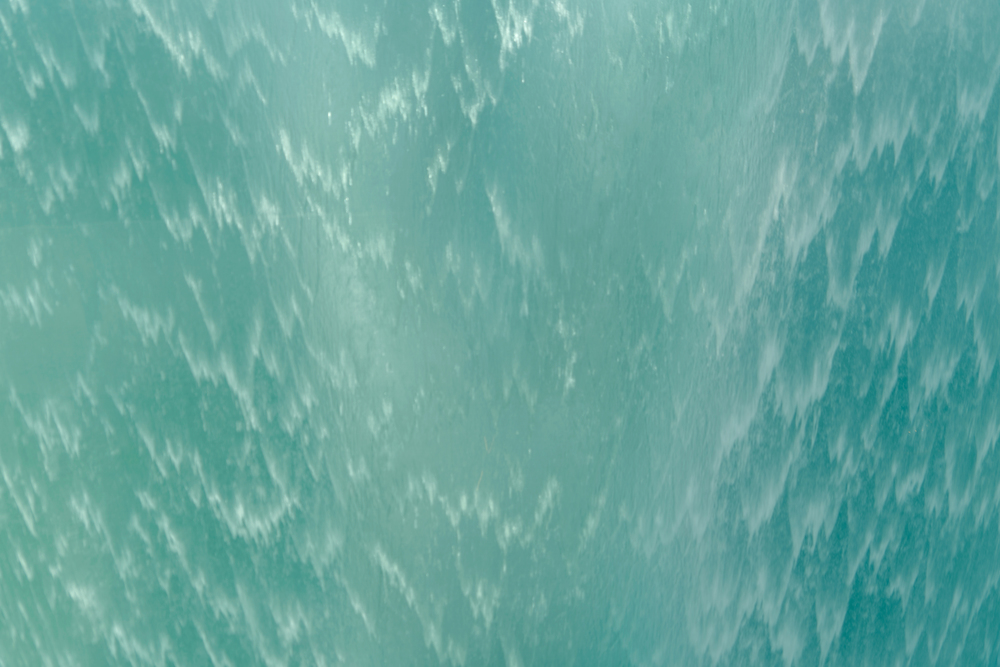 Close up of surface. Blue or turquoise waterfall or swimming pool texture. Pattern background of water.