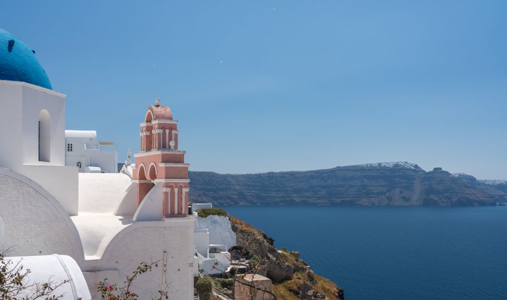 Traditional Greek Orthodox church with bell tower in village of Oia on Santorini. Belltower and bells on Greek Orthodox church in Oia
