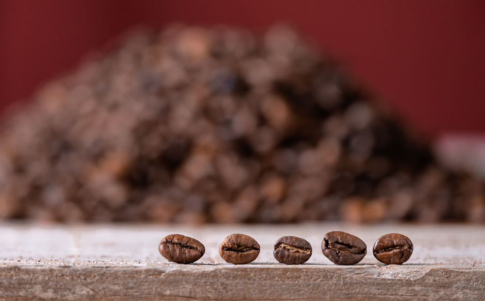 coffee beans in the foreground on wooden board