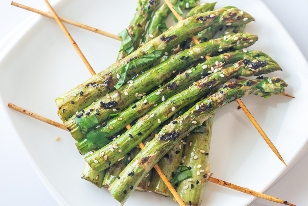 Grilled asparagus rafts with sesame seeds on the plate