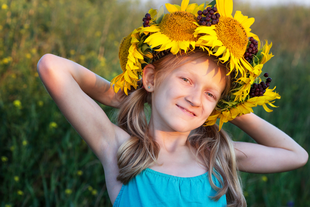 Ukrainian kid girl at the field of sunflowers in a field of sunflowers. Ukraine