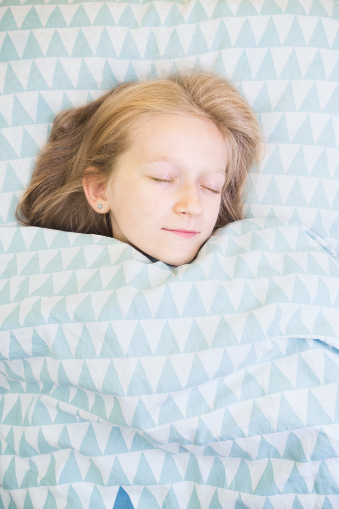 little girl lies in bed before bedtime. sleep and health