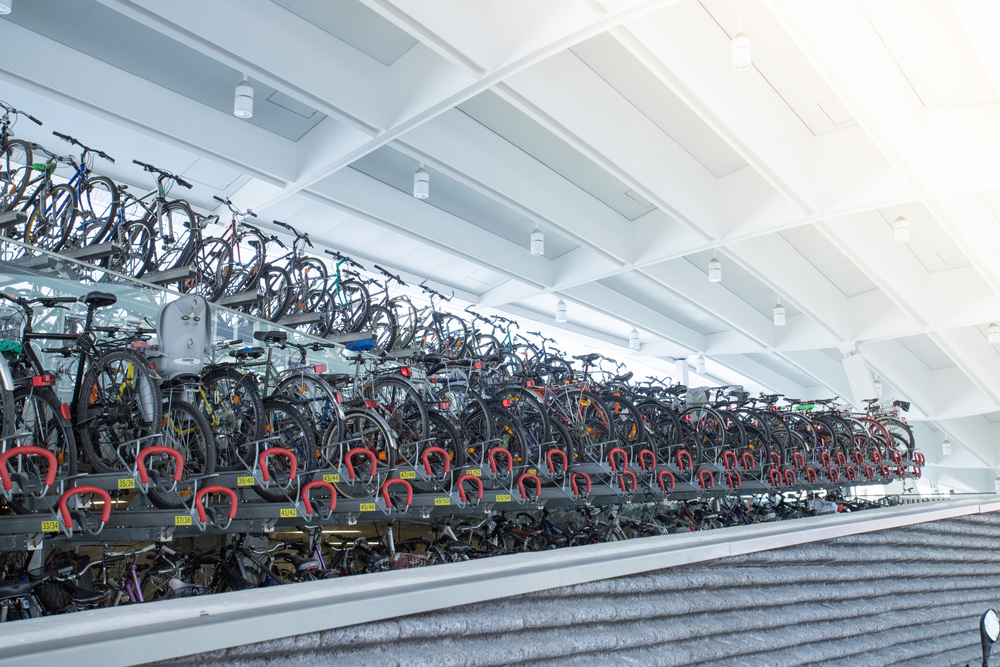 Many parked bikes on a train station, rack
