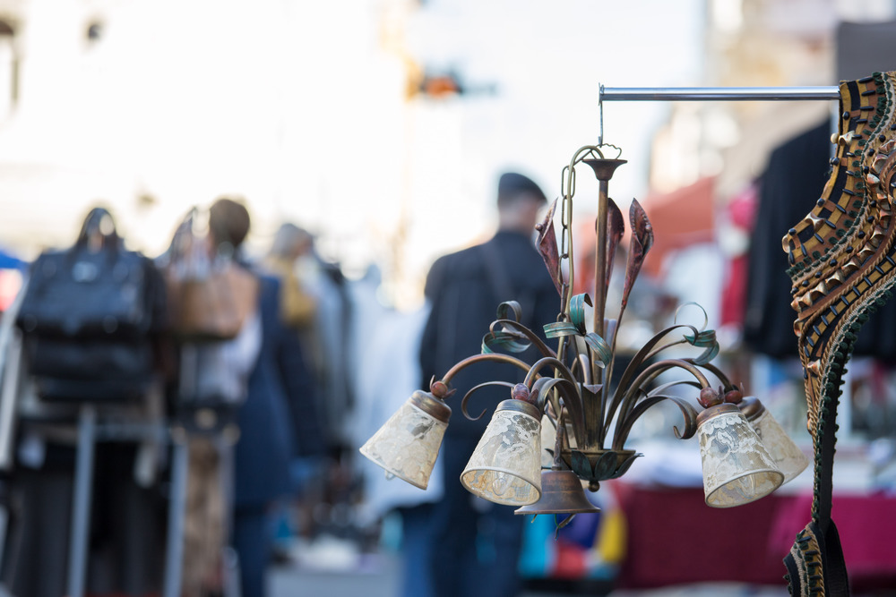 Old fashioned lamp on a flea market, people in the blurry background