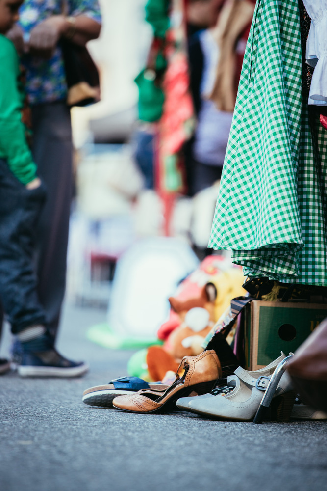 Shoes, dresses and stuff on a flea market, people in the blurry background