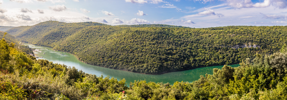 Landscape in Croatia: Timberland, river and blue sky with clouds