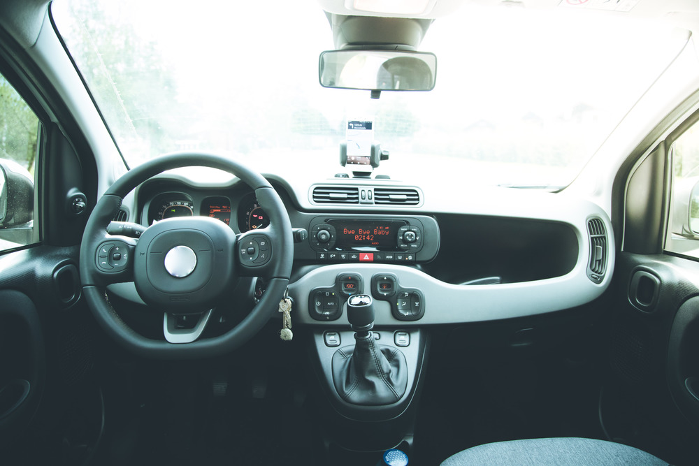 Interior of a modern car on a sunny day. Smartphone on mobile mount, used as navigation device
