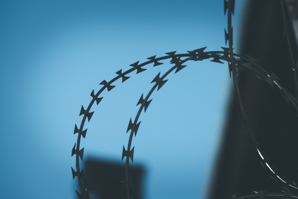 Close up perspective of barbed wire in the prison or on a military base