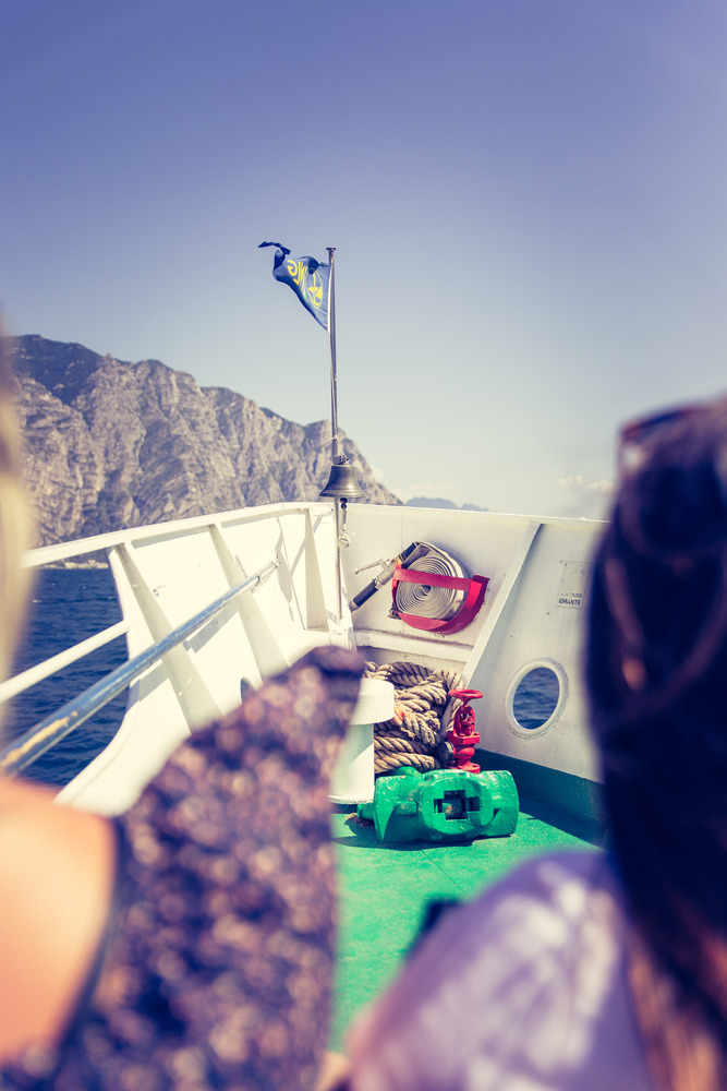 Tourists on a boat tour. Blue sky, white ship bow. Lago di garda, Italy