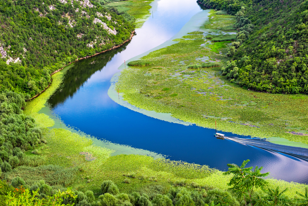Boat on river in mountains of Montenegro, view from above. Boat on river in mountains
