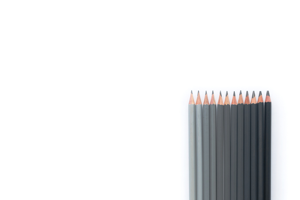 Many gray pencils on a white background. Top view. Row of gray pencils on a white background. Top view. Copyspace