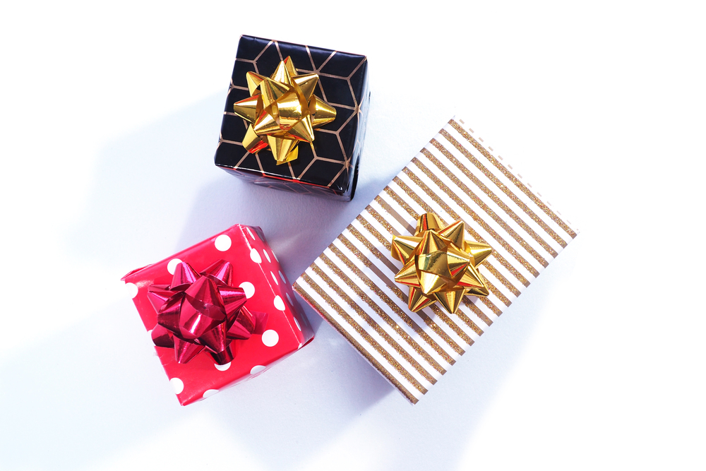 Black and gold, red and white polka dots and white and gold three gift boxes with gold and red bows on a white background.