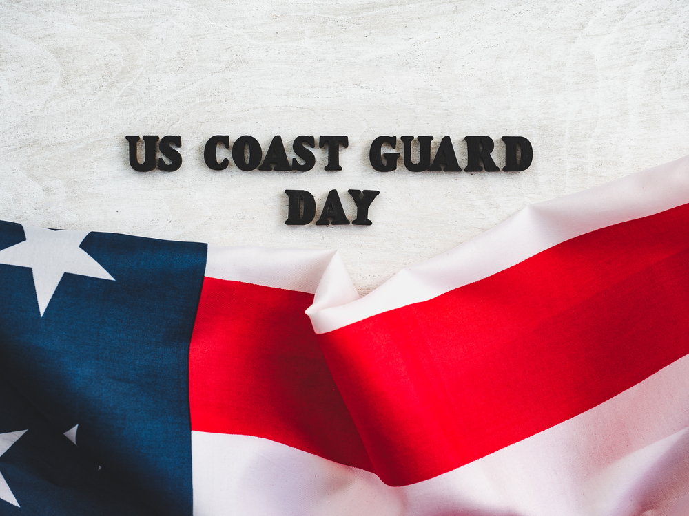 Beautiful card for US Coast Guard Day. Wooden letters with a congratulatory inscription on a white background. Close-up, top view. Congratulations for loved ones, relatives, friends and colleagues. Beautiful, bright greeting card with a holiday
