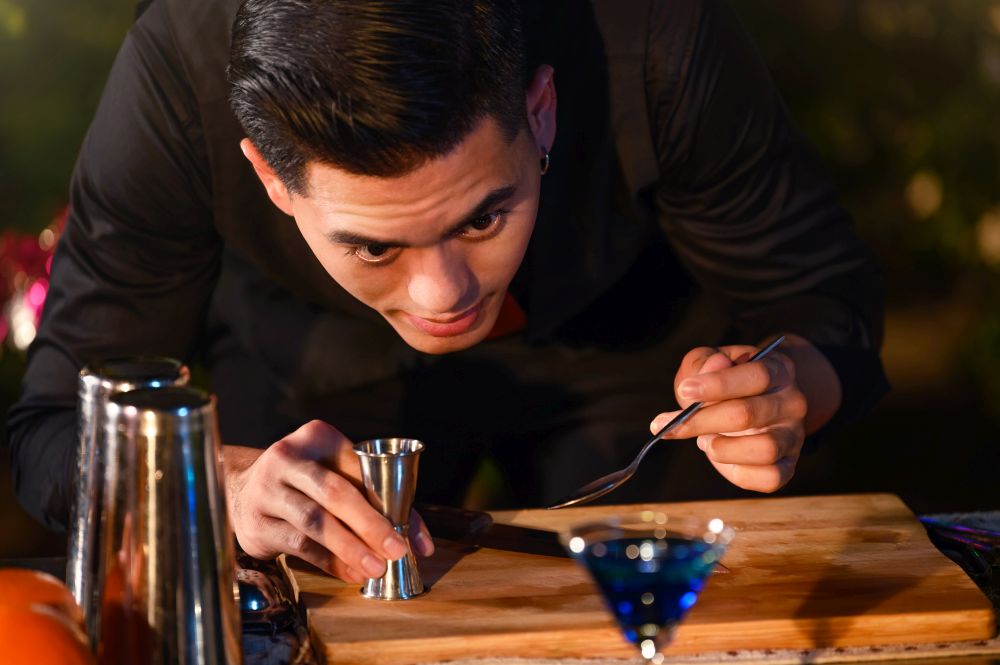 Professional bartender preparing fresh juice cocktail in drinking wine glass with ice at night bar clubbing counter. Occupation and people lifestyles concept. Outdoor and nightclub background