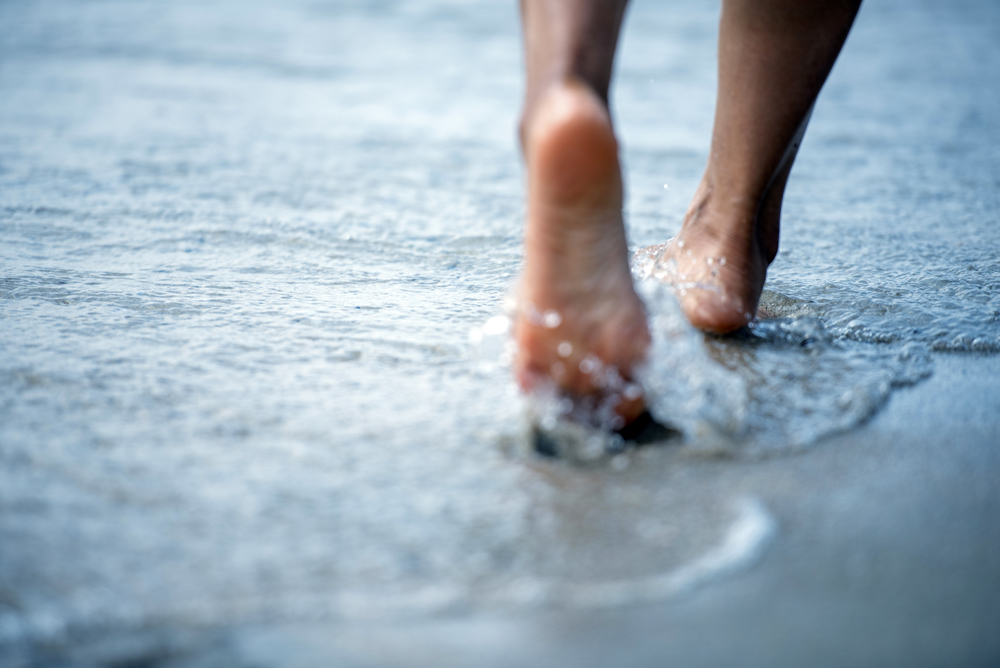Woman barefoot walking on the beach