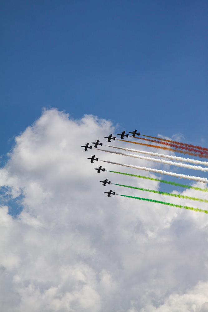 At Air Show, squadrons of aircraft emit colorful smoke