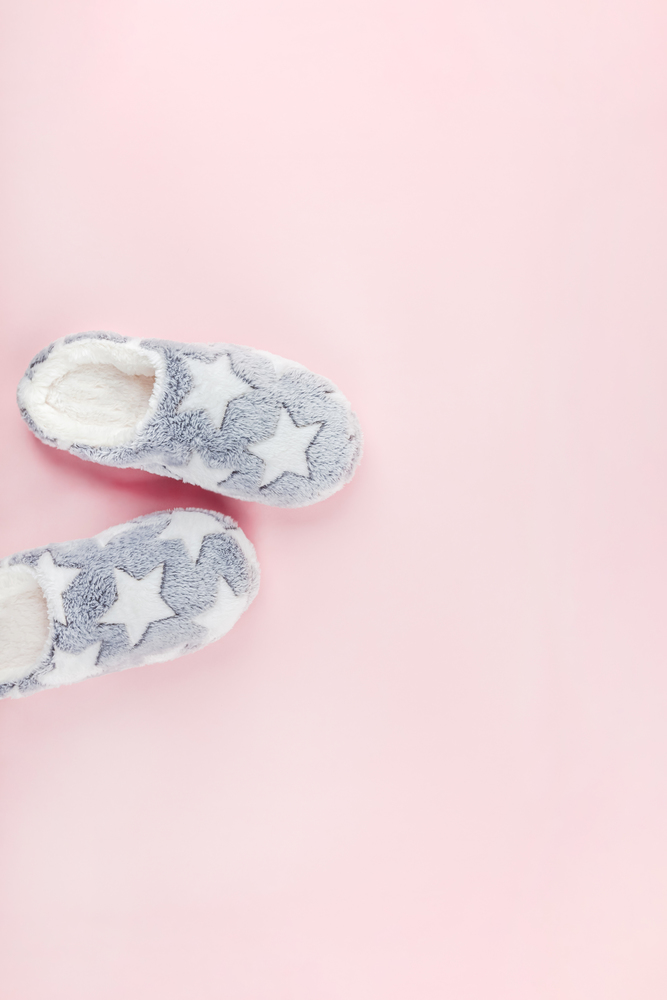 Sleep. Soft fluffy slippers on pink background. Creative conceptual top view flat lay in minimal style. Rest, good night, insomnia, relaxation, tired, hygge concept