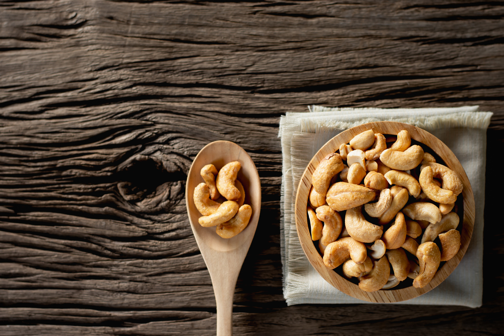 Cashew nuts are placed on the old wooden table.