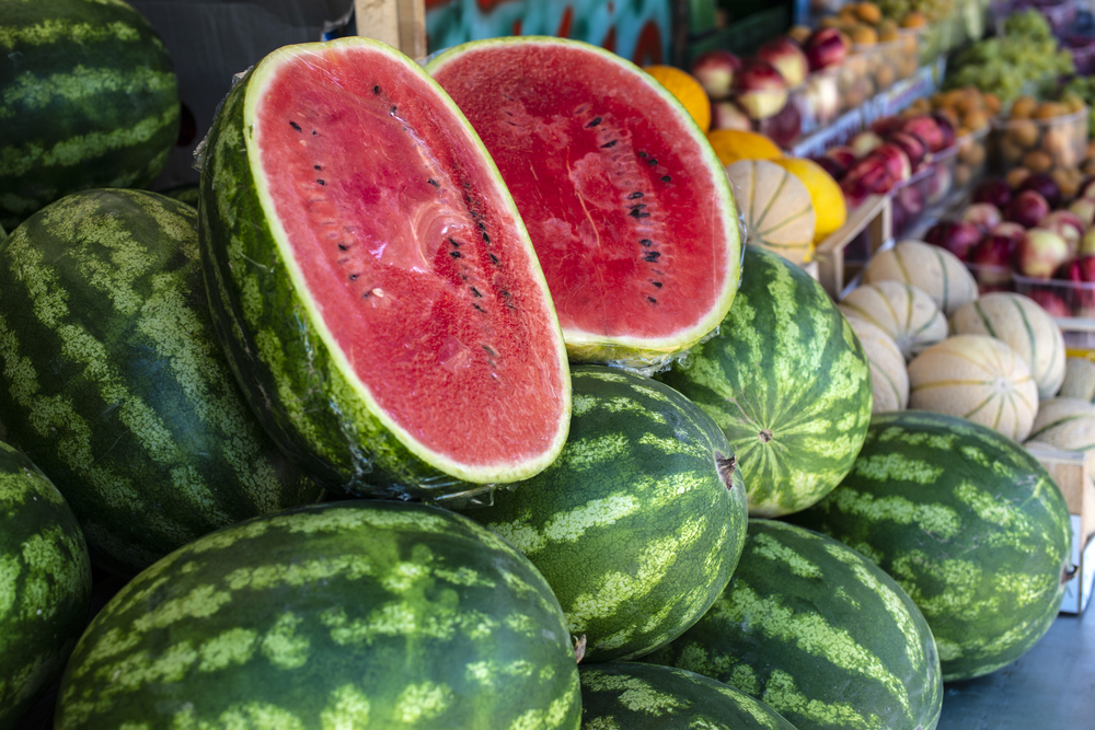 Watermelons on shelf. Cutted watermelon on street market. Summer Fruits.