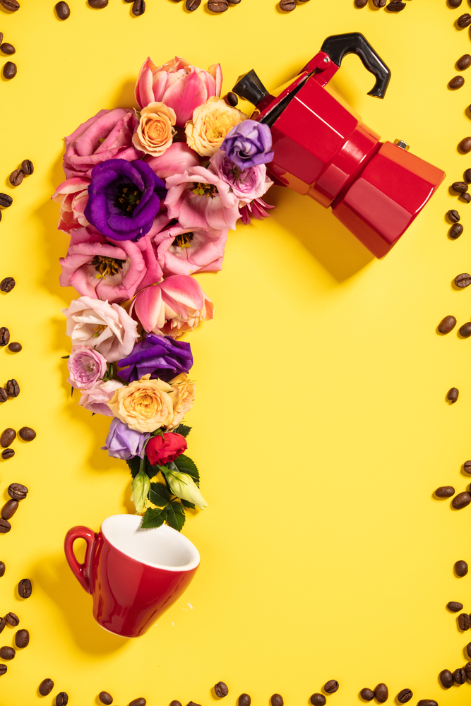 Morning coffee concept. Coffee maker, coffee cup and flowers on yellow background. Flat lay