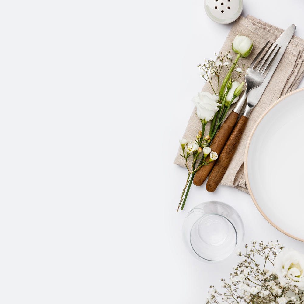 Empty white plate and cutlery on a napkin, flat lay on white background. Empty white plate and cutlery on a napkin