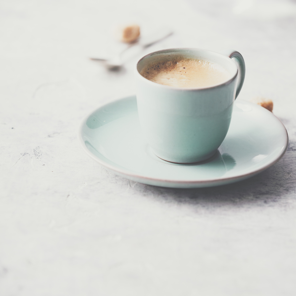 A cup of coffee on light grey background, coffee break concept. A cup of coffee on light grey background