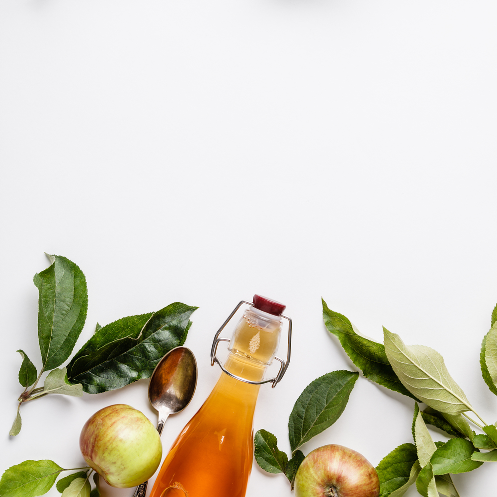 Apple cider vinegar and fresh apples, flat lay, space for your text. Fermented food concept. Apple cider vinegar and fresh apples, flat lay, space for your text
