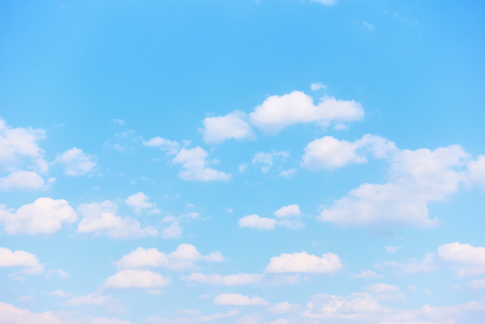 Pastel blue spring sky with light white clouds -  Natural background