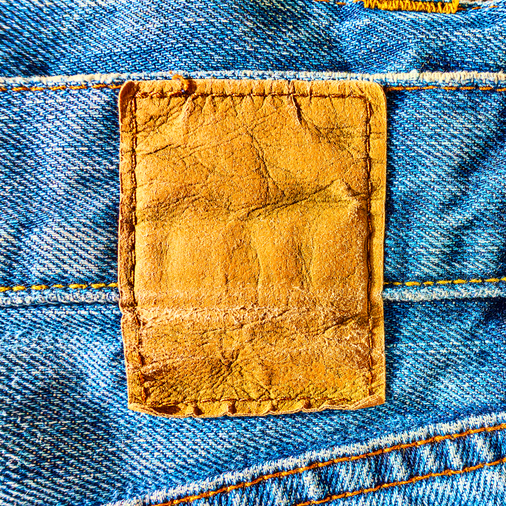 Blank leather label sewed on a blue jeans