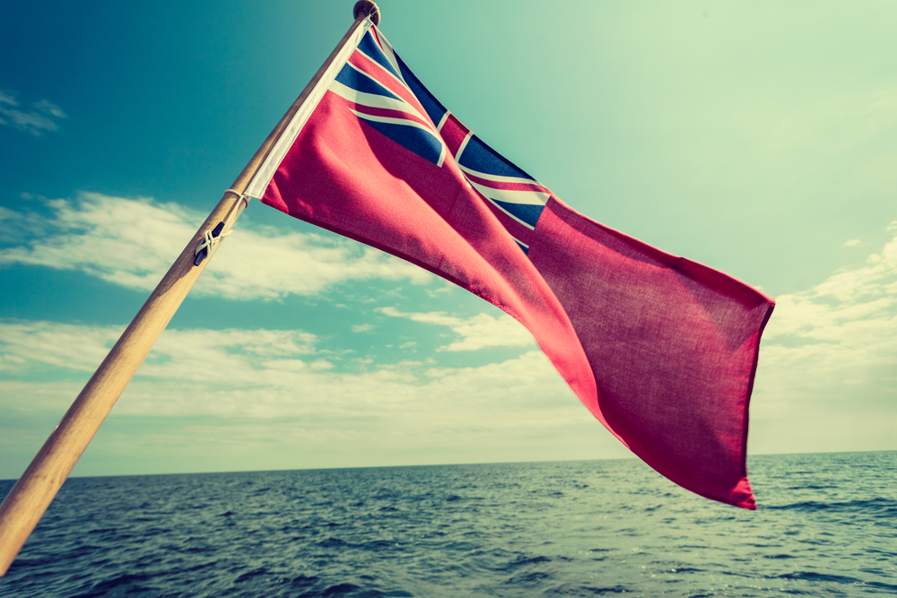 The uk red ensign the british maritime flag flown from yacht sail boat, blue sky and baltic sea. Summer and travel voyage. uk red ensign the british maritime flag flown from yacht