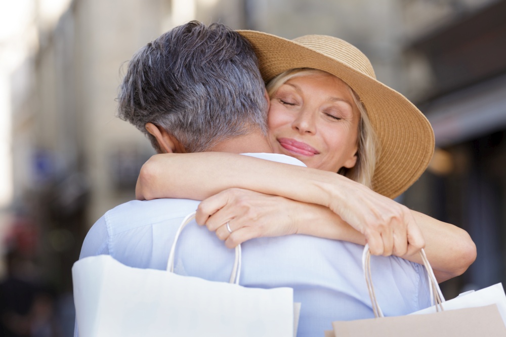 smiling couple hugging and holding shopping bags