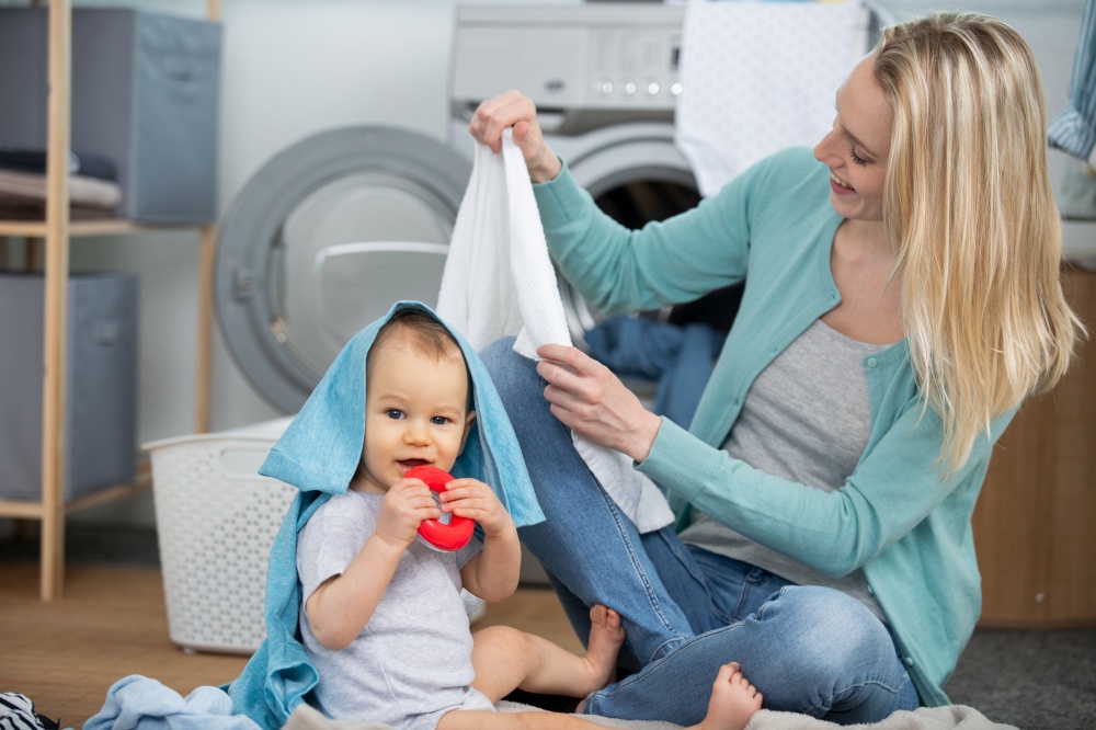 mother with a baby engaged in laundry fold clothes