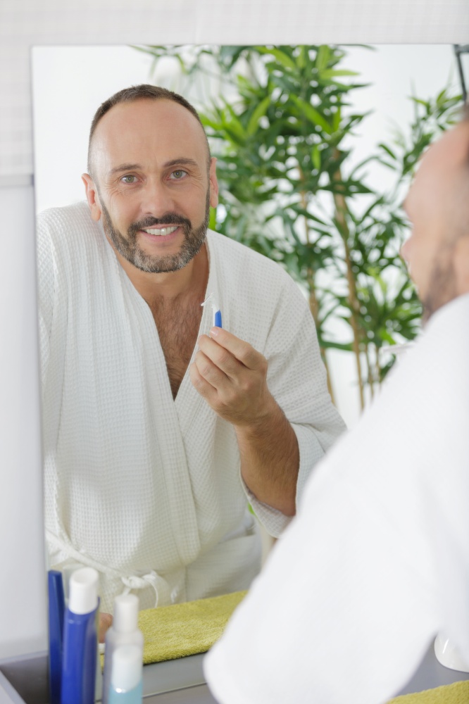 man shaving in a mirror